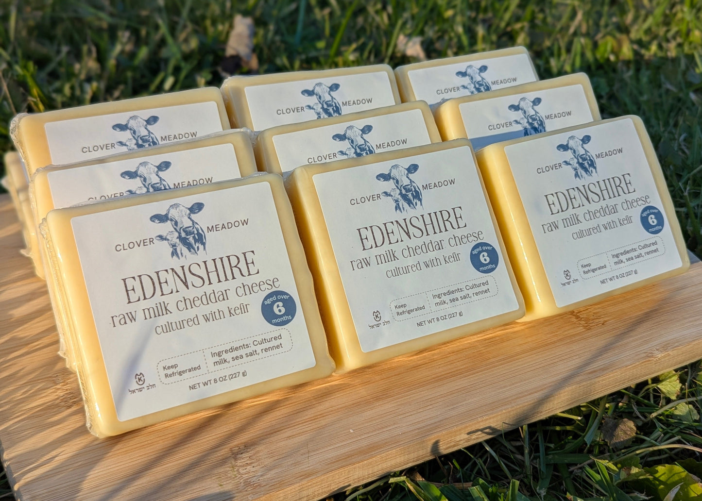 Cheese block with a label on a wooden surface and grassy background
